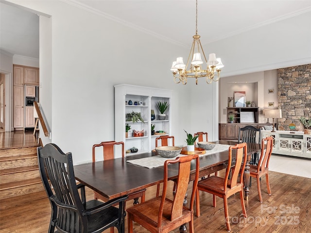 dining space with ornamental molding, light wood finished floors, stairs, and an inviting chandelier