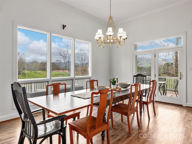 dining space with baseboards, ornamental molding, and light wood-style floors