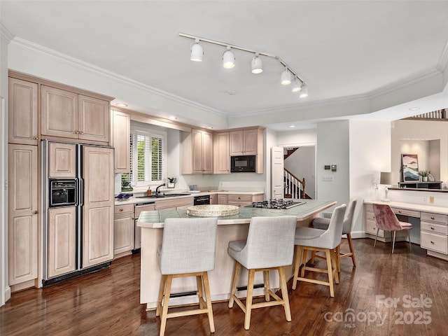 kitchen with ornamental molding, dark wood finished floors, a kitchen bar, and built in appliances