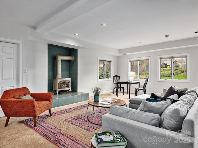 living area featuring recessed lighting, a wood stove, a healthy amount of sunlight, and baseboards