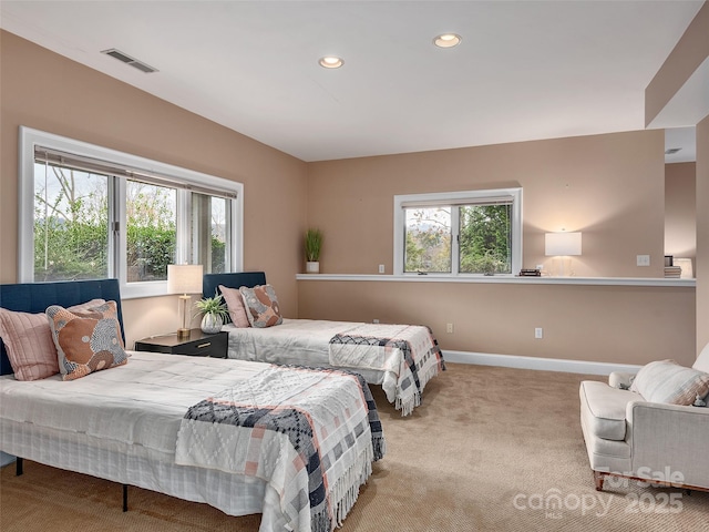 bedroom with carpet floors, multiple windows, visible vents, and baseboards