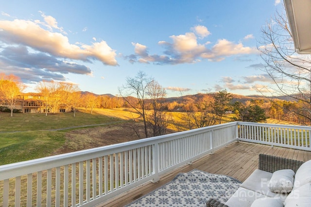 wooden terrace featuring a yard and a mountain view