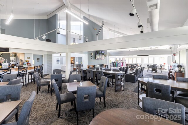 dining area with carpet flooring, visible vents, and track lighting