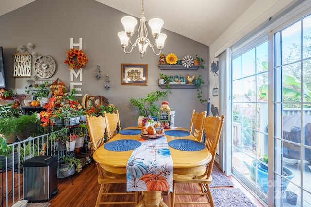 dining space featuring a notable chandelier, vaulted ceiling, and hardwood / wood-style flooring