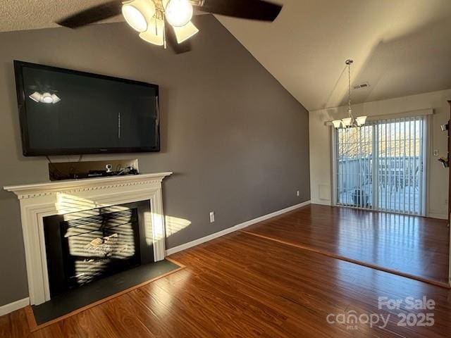 unfurnished living room with hardwood / wood-style flooring, lofted ceiling, and ceiling fan with notable chandelier