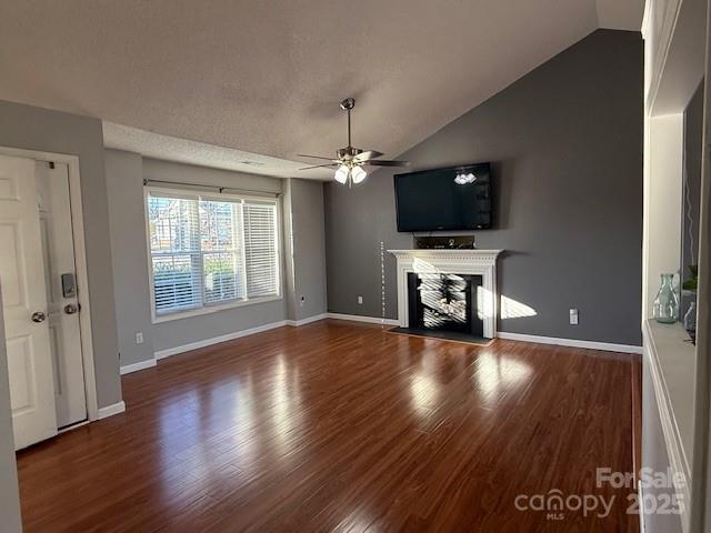 unfurnished living room with vaulted ceiling, ceiling fan, and dark hardwood / wood-style flooring