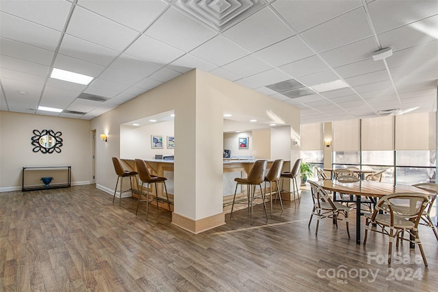 dining space with dark hardwood / wood-style flooring and a paneled ceiling