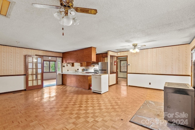 kitchen with a textured ceiling, stainless steel appliances, ceiling fan, and light parquet flooring