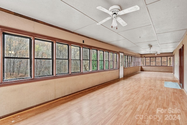 unfurnished sunroom with ceiling fan and a healthy amount of sunlight