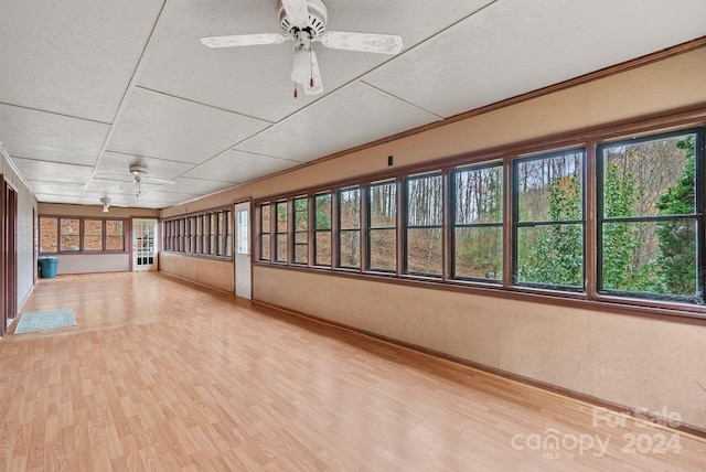 unfurnished sunroom with ceiling fan