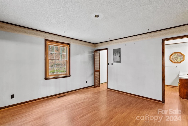 unfurnished room featuring light hardwood / wood-style floors, a textured ceiling, and electric panel