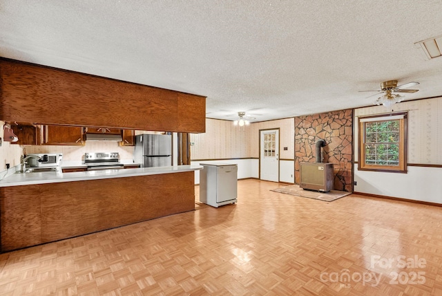 61 Doe Loop, Hot Springs, NC 28743 - kitchen featuring stainless steel appliances, wallpapered walls, a wood stove, a peninsula, and light countertops