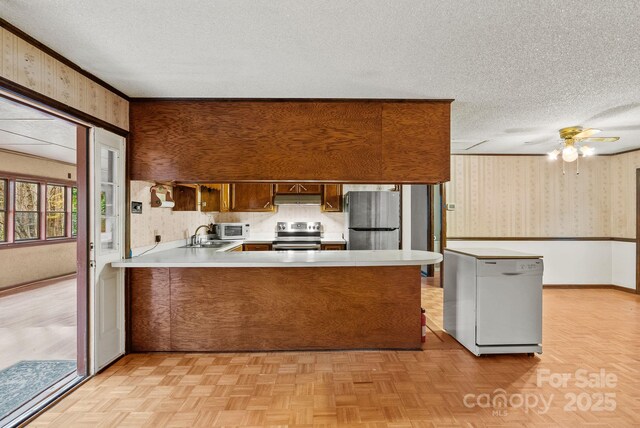 61 Doe Loop, Hot Springs, NC 28743 - kitchen featuring stainless steel appliances, wallpapered walls, a textured ceiling, a peninsula, and light countertops