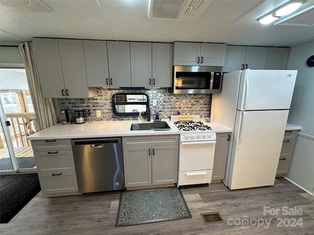 kitchen with decorative backsplash, sink, stainless steel appliances, and light hardwood / wood-style floors