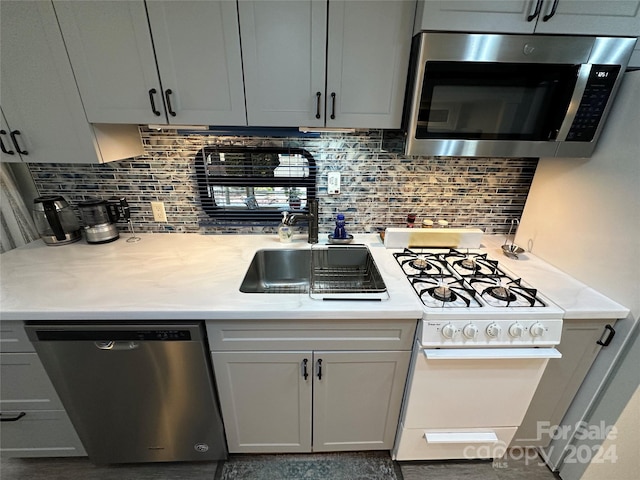 kitchen with gray cabinetry, decorative backsplash, and appliances with stainless steel finishes