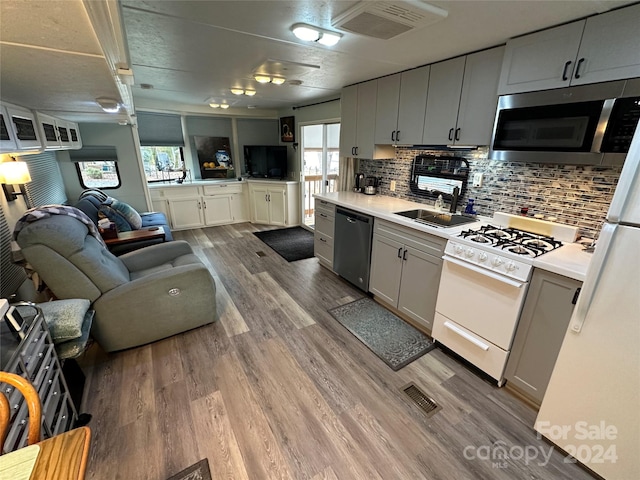 kitchen featuring light hardwood / wood-style flooring, appliances with stainless steel finishes, a healthy amount of sunlight, and tasteful backsplash