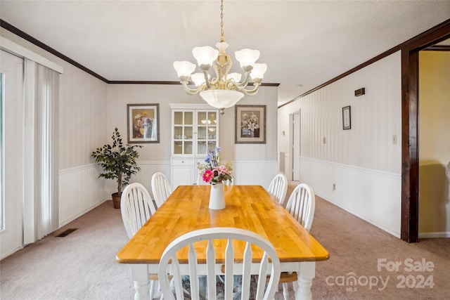 dining room featuring light carpet, a chandelier, and ornamental molding