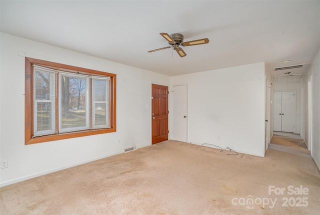 carpeted spare room featuring ceiling fan