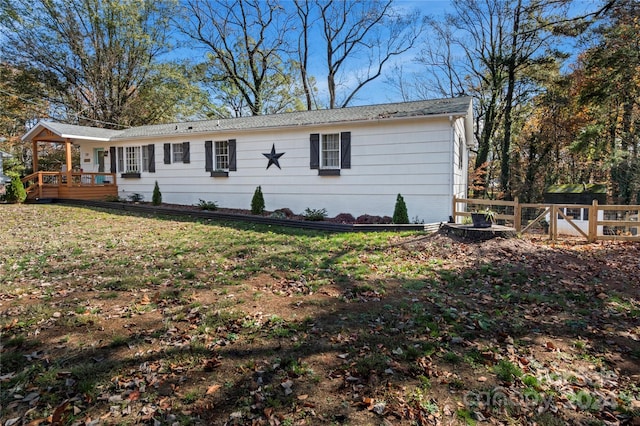 exterior space featuring a wooden deck and a front yard