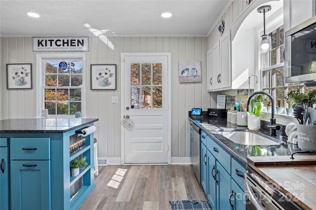 kitchen featuring white cabinets, light hardwood / wood-style floors, blue cabinetry, and a healthy amount of sunlight