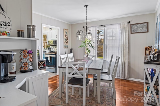 dining room featuring crown molding, hardwood / wood-style floors, and an inviting chandelier