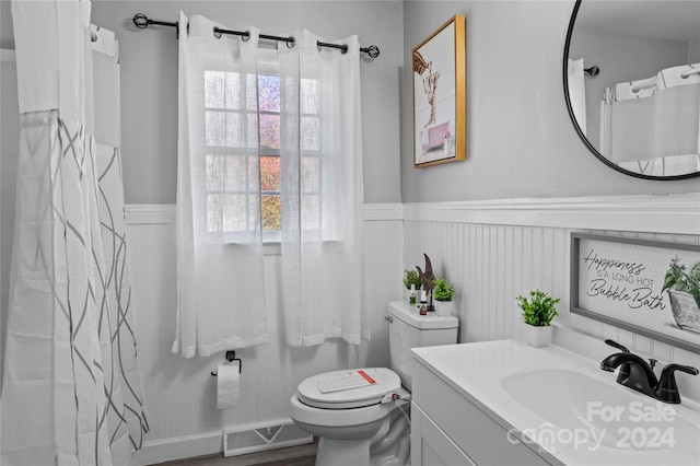 bathroom with hardwood / wood-style floors, vanity, and toilet