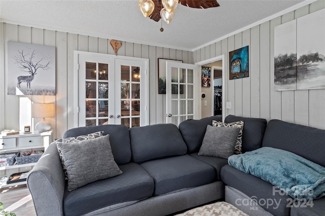 living room with ornamental molding, hardwood / wood-style floors, a textured ceiling, french doors, and ceiling fan