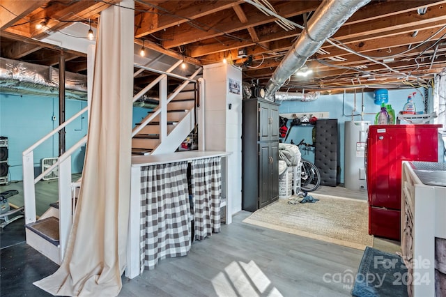 basement with wood-type flooring and electric water heater