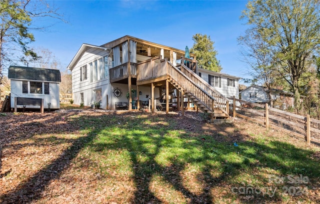 back of property with a yard and a wooden deck