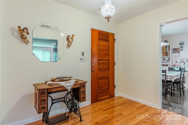 foyer entrance with light wood-type flooring and baseboards