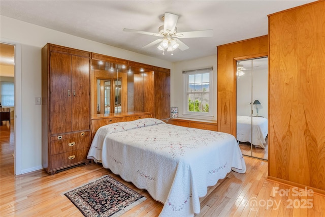 bedroom with a closet, baseboards, light wood-style floors, and a ceiling fan