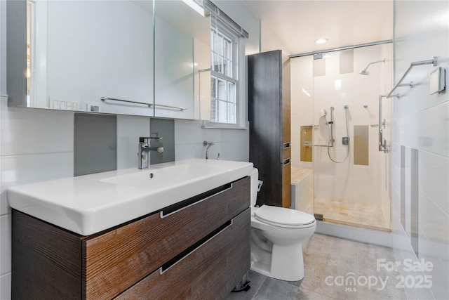 bathroom with a shower stall, toilet, and vanity