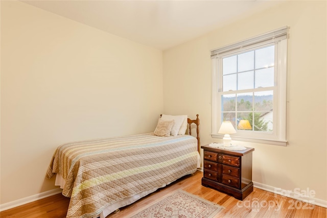 bedroom featuring wood finished floors and baseboards