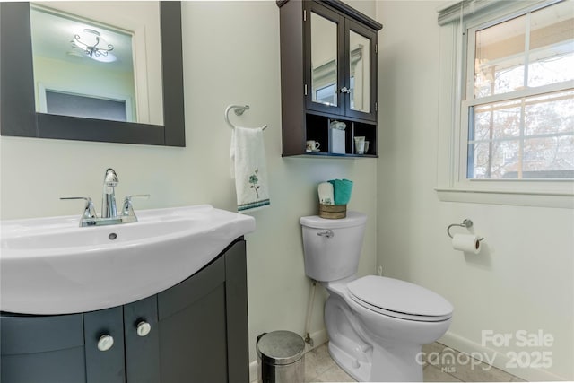 bathroom featuring tile patterned floors, baseboards, toilet, and vanity