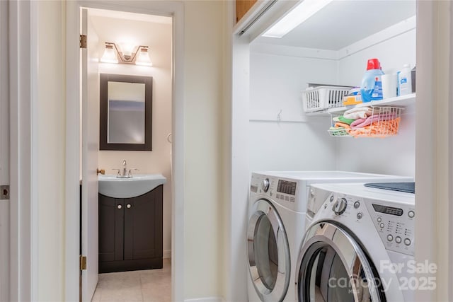 washroom with light tile patterned floors, separate washer and dryer, laundry area, and a sink