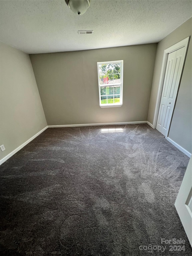 carpeted spare room with a textured ceiling