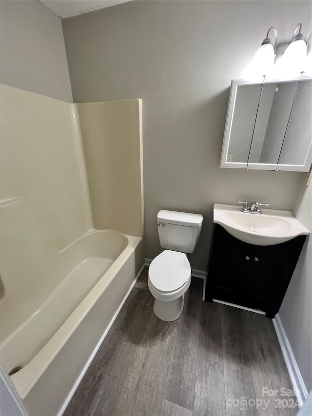 full bathroom with hardwood / wood-style floors, vanity, toilet, and shower / washtub combination