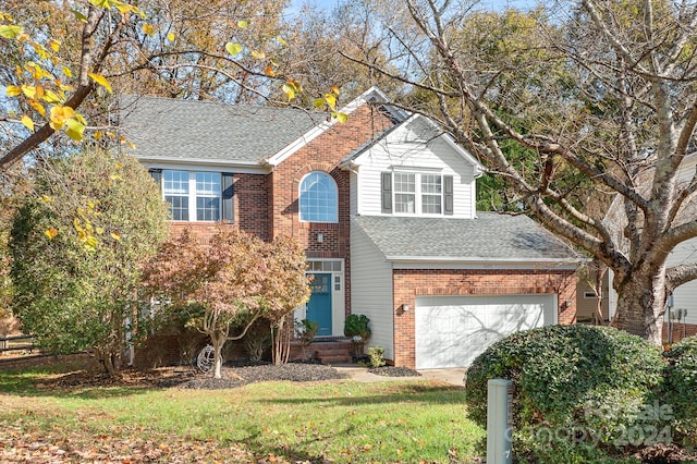 view of property featuring a front lawn and a garage