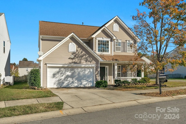 view of front of property featuring covered porch, a garage, and a front yard