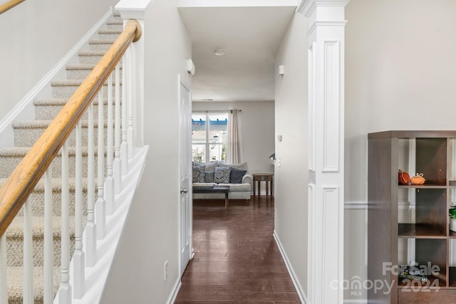 hallway featuring dark hardwood / wood-style floors and decorative columns