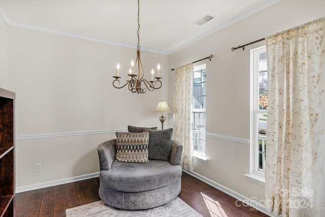 sitting room with dark hardwood / wood-style floors, crown molding, and an inviting chandelier