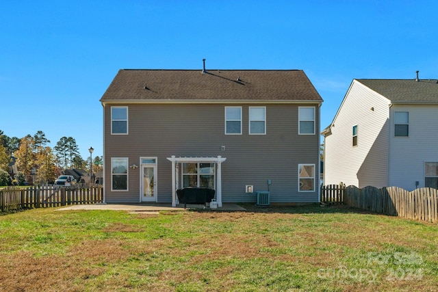 rear view of house with a pergola, a patio area, a yard, and central AC