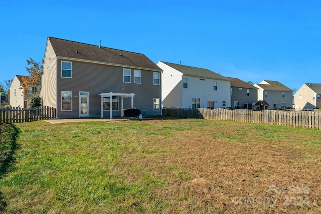 rear view of property with a pergola, a patio area, and a lawn