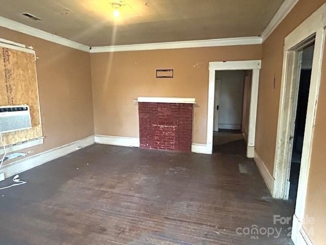 unfurnished living room with dark wood-type flooring, a fireplace, and crown molding