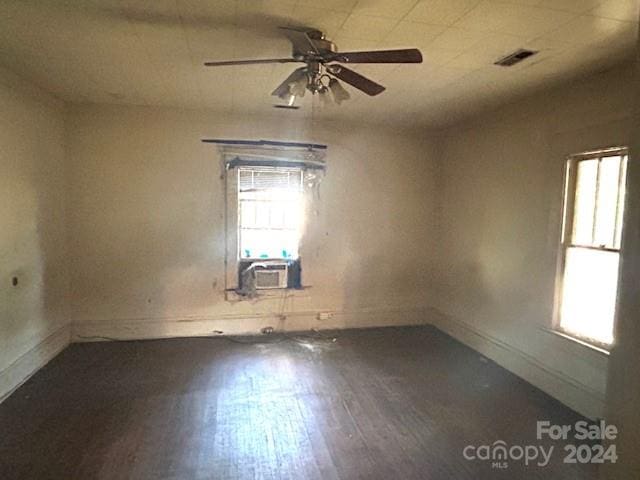 unfurnished room featuring dark wood-type flooring, ceiling fan, and cooling unit