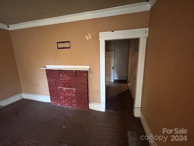 unfurnished living room with dark hardwood / wood-style flooring and ornamental molding