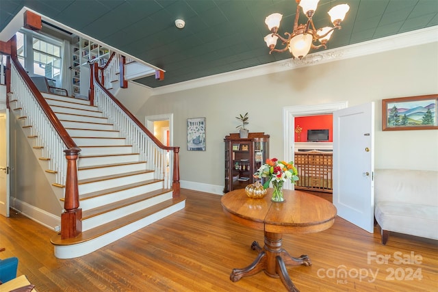 interior space featuring crown molding, hardwood / wood-style floors, and an inviting chandelier