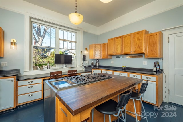 kitchen with a breakfast bar, dark wood-type flooring, decorative light fixtures, and a kitchen island