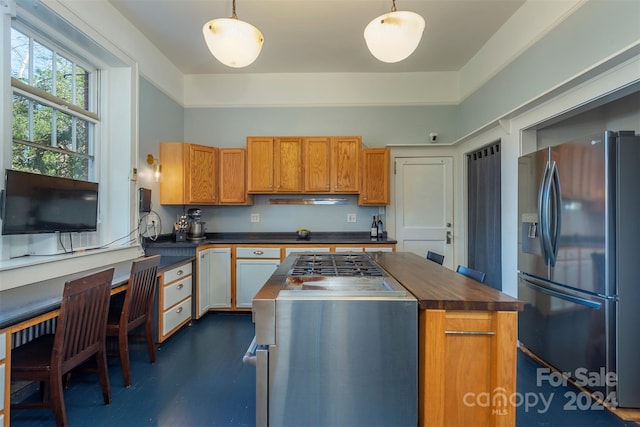 kitchen with stainless steel refrigerator with ice dispenser, a center island, and pendant lighting