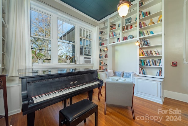 miscellaneous room with hardwood / wood-style floors, built in features, and cooling unit